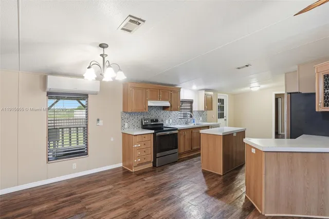 a large kitchen with cabinets wooden floor and stainless steel appliances