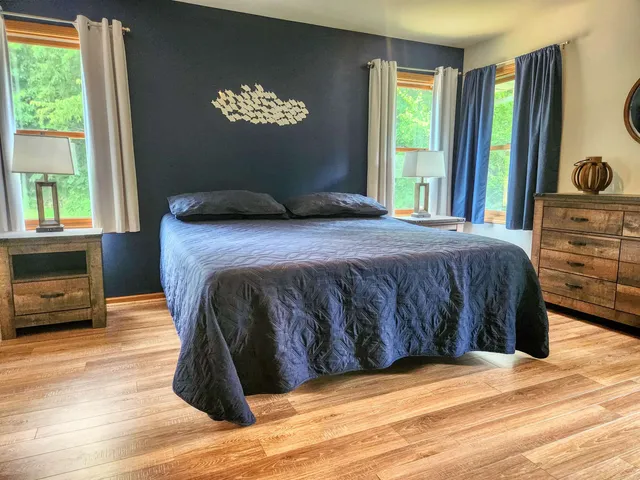 a bedroom with a bed and a large window