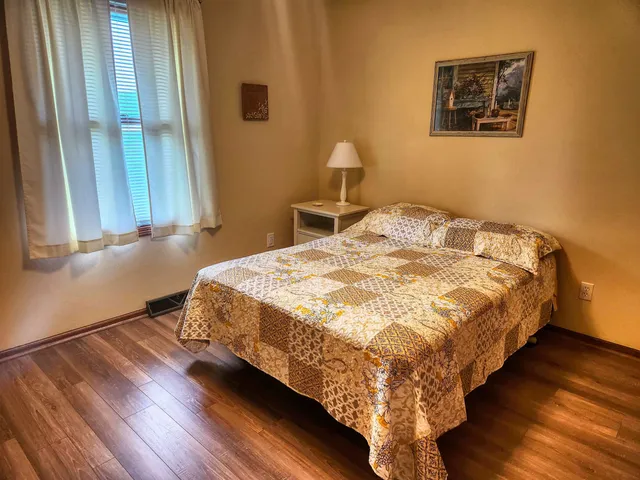 a bed sitting in a bedroom next to a window