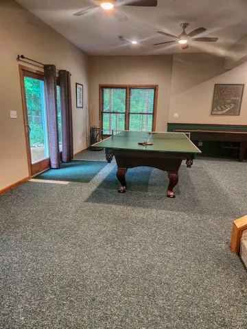 a living room with furniture pool table and a window