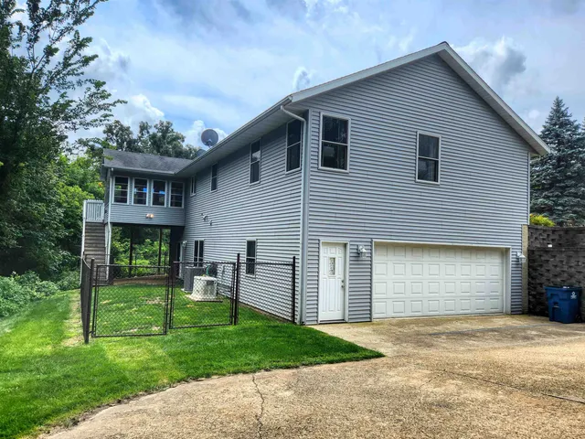 a view of a house with a patio and a yard