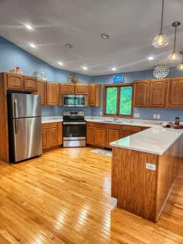 a kitchen with stainless steel appliances granite countertop a sink refrigerator and microwave