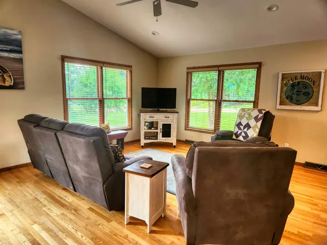 a living room with furniture a flat screen tv and a window