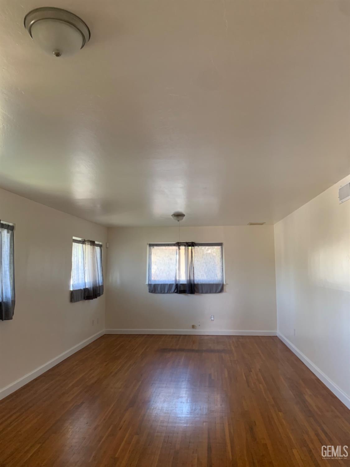 Undisclosed Address Bakersfield, CA 93306 - Photo 5 of 18 an empty room with wooden floor and windows