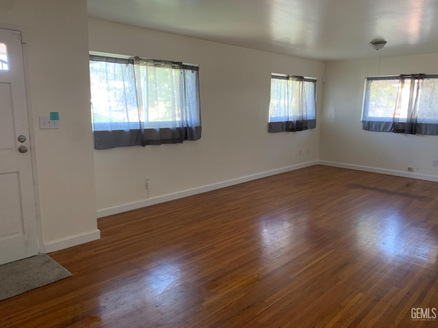 Undisclosed Address Bakersfield, CA 93306 - Photo 6 of 18 an empty room with wooden floor and windows