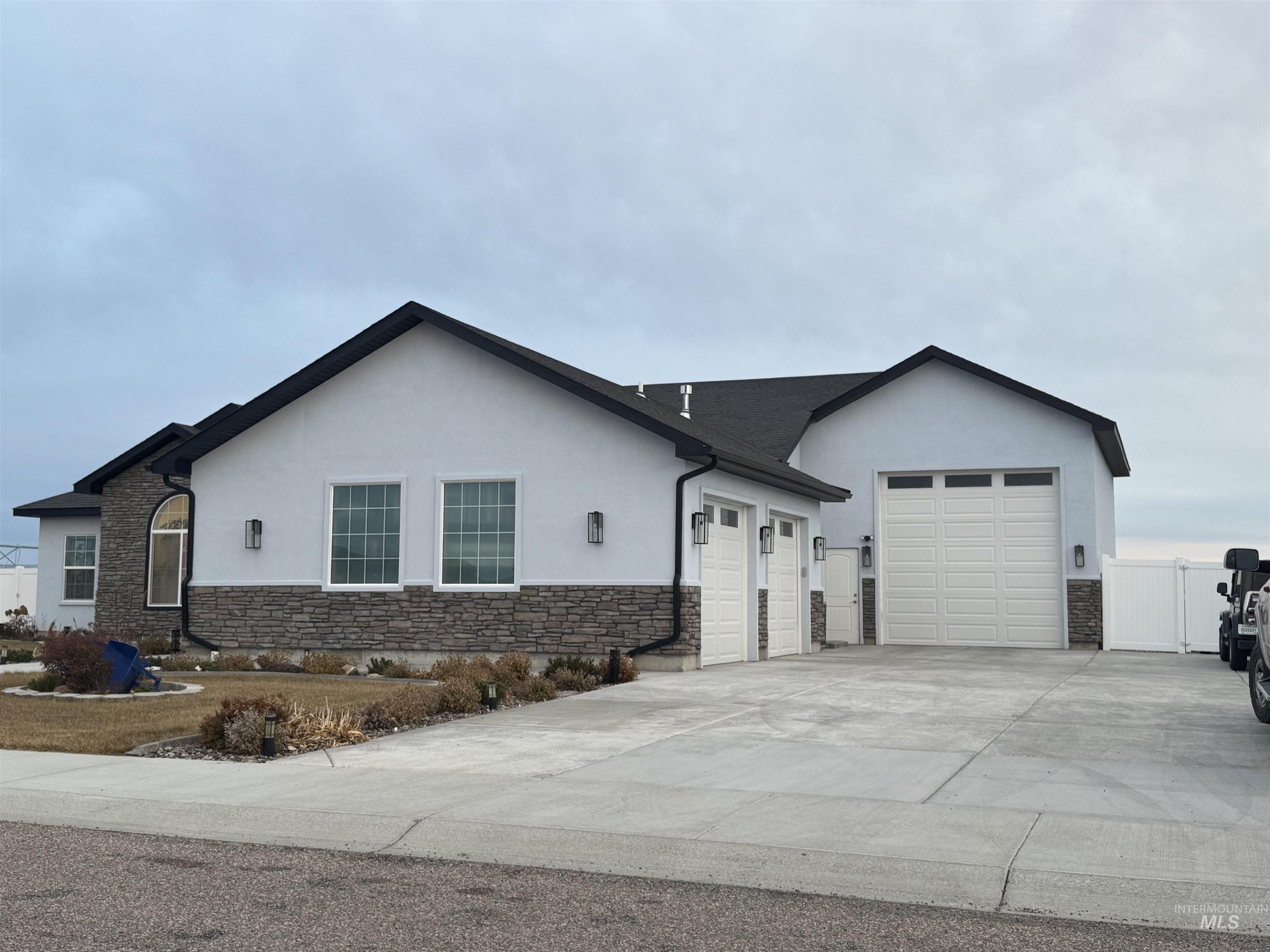 Ranch-style home with stucco siding and stone siding