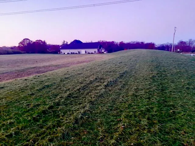 a view of a road with a house in the background