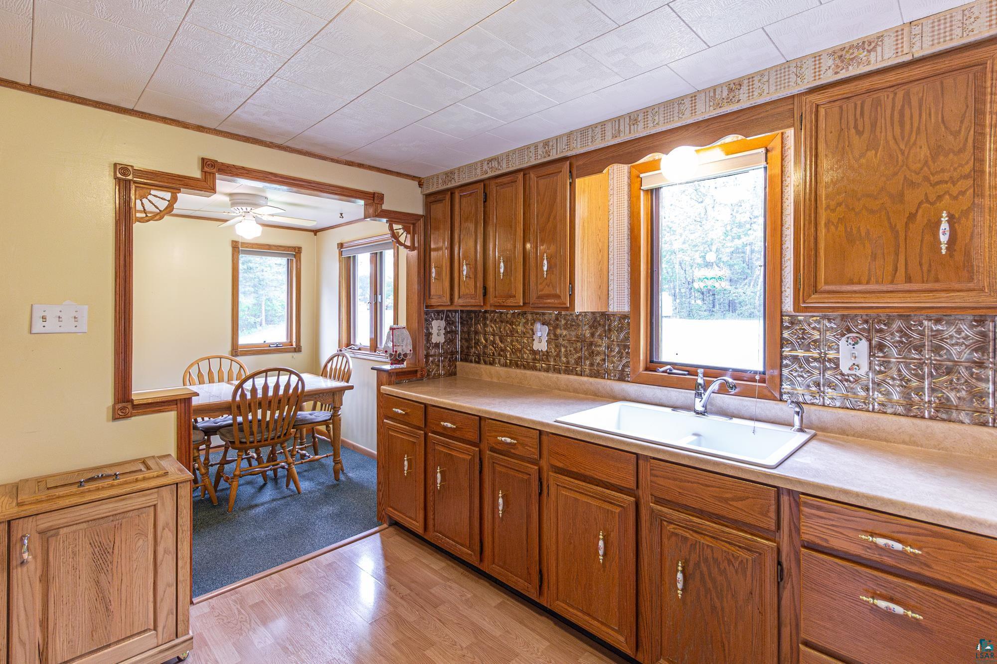 1775 Lookout Road Ely, MN 55731 - Photo 10 of 44 Kitchen featuring a wealth of natural light, sink, ceiling fan, and tasteful backsplash