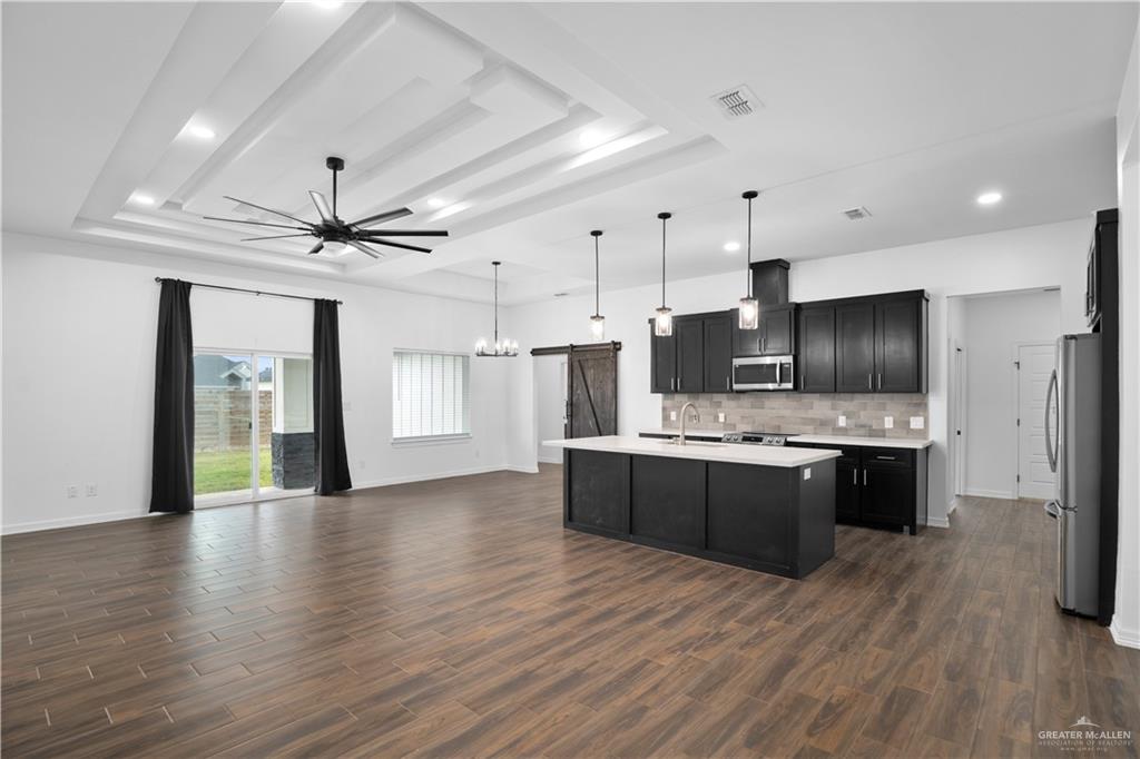 3701 South Solstice Road Edinburg, TX 78542 - Photo 3 of 17 a large kitchen with stainless steel appliances granite countertop a stove and a refrigerator