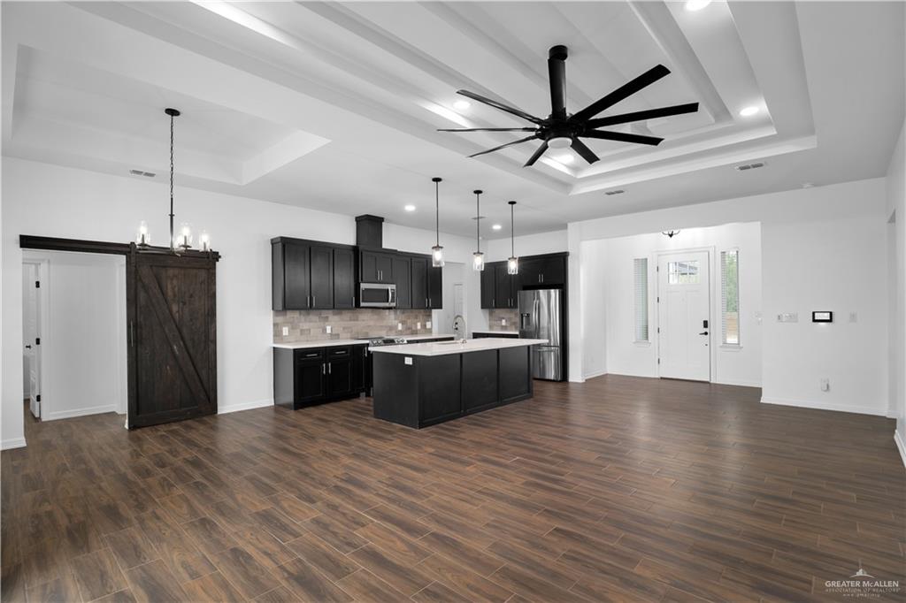 3701 South Solstice Road Edinburg, TX 78542 - Photo 4 of 17 a large kitchen with stainless steel appliances kitchen island a stove top oven a sink and refrigerator