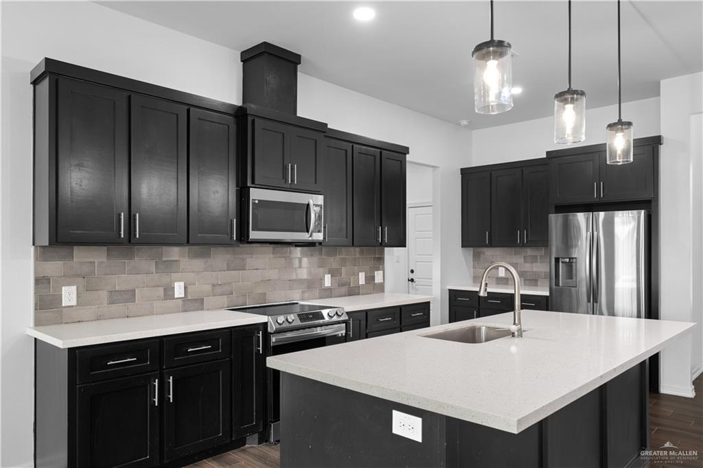 3701 South Solstice Road Edinburg, TX 78542 - Photo 5 of 17 a kitchen with stainless steel appliances a sink stove and refrigerator