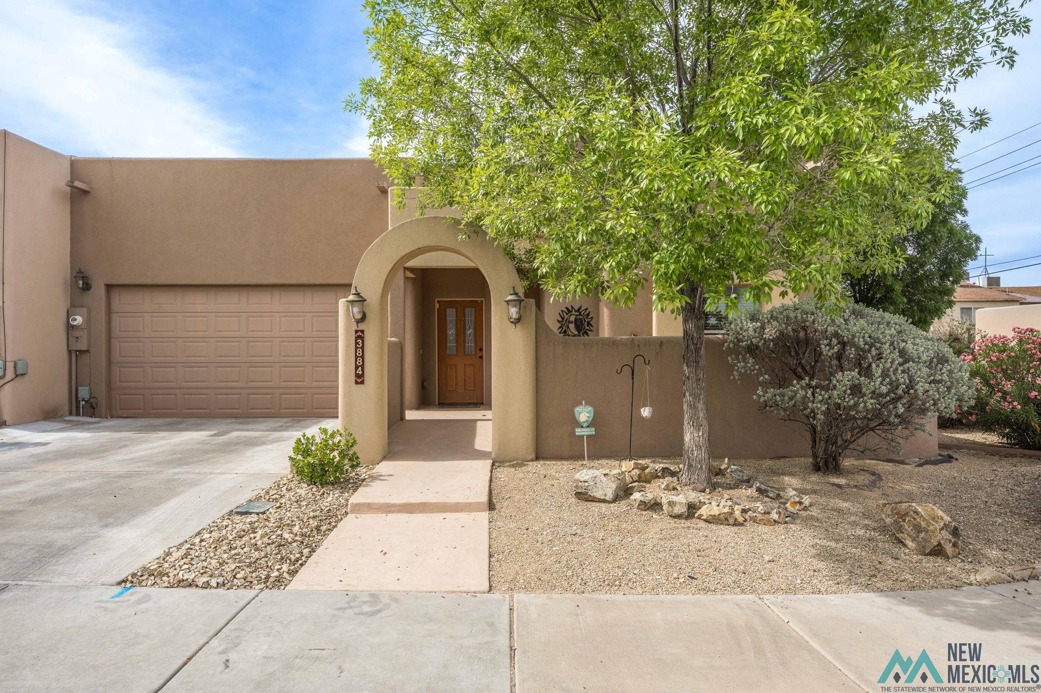 3884 Adriatic Road Las Cruces, NM 88012 - Photo 1 of 45 Stucco exterior with an arched entryway and a wood-paneled front door