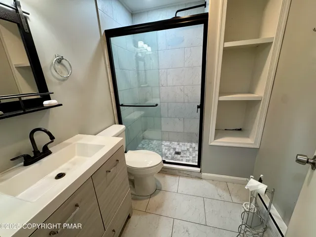 a bathroom with a sink a toilet and shower