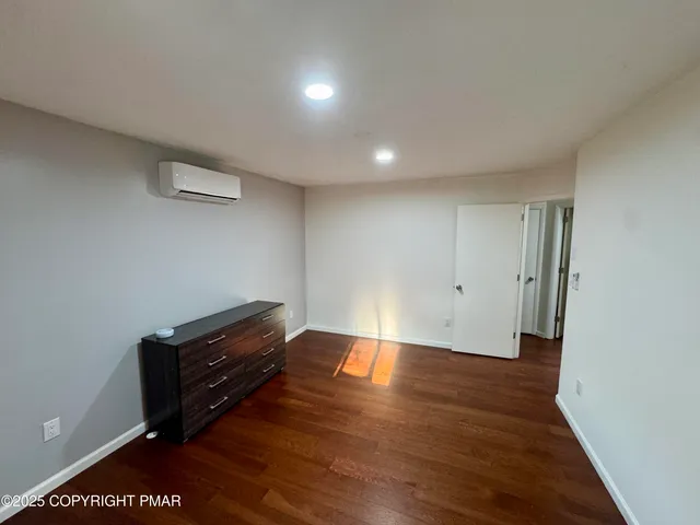 a view of empty room with wooden floor and window