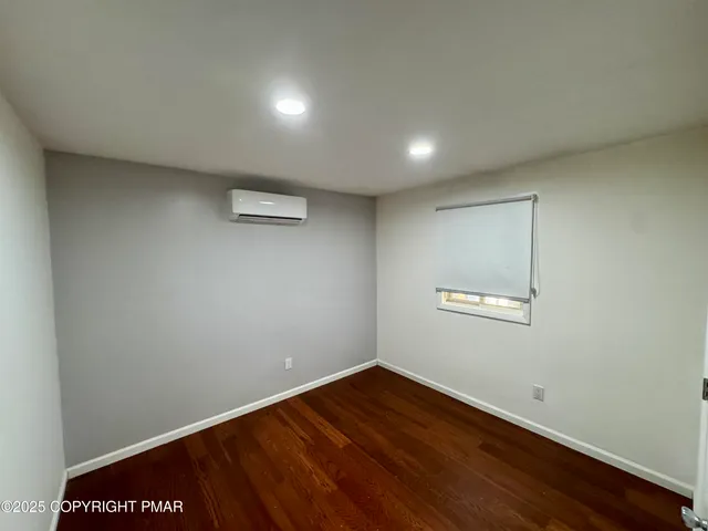 an empty room with wooden floor and closet