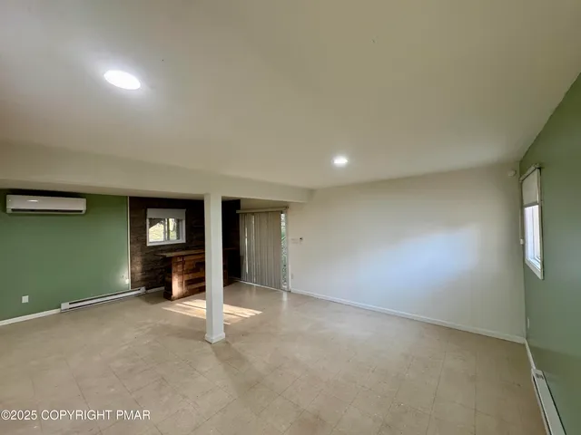 an empty room with fireplace and windows