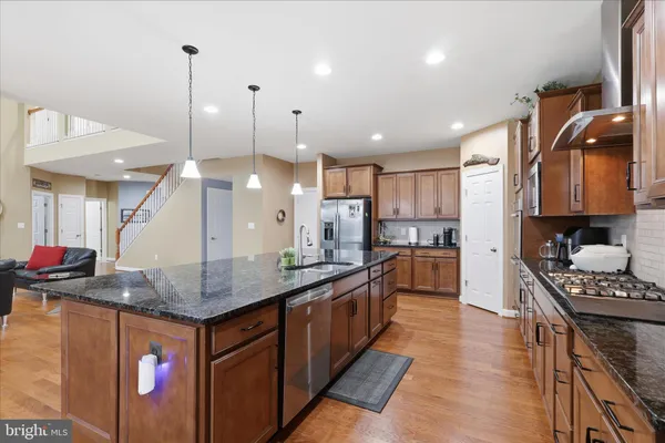 a kitchen with stainless steel appliances granite countertop a stove a sink and a microwave