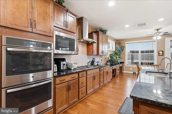 a kitchen with stainless steel appliances granite countertop a stove and a refrigerator