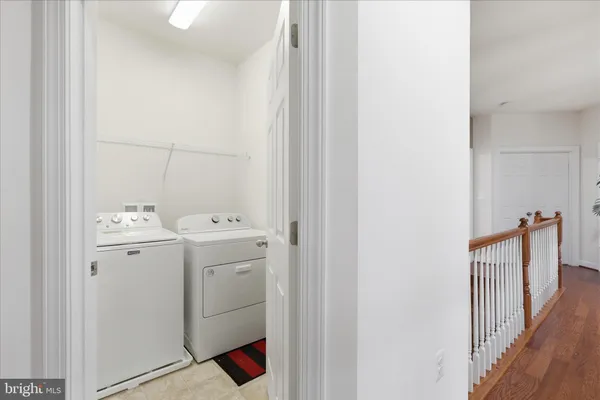 a view of a hallway with wooden floor and a potted plant