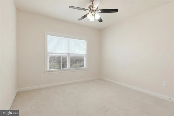 a view of an empty room with wooden floor and stairs