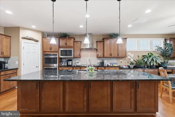 a kitchen with stainless steel appliances granite countertop a sink a stove and a refrigerator