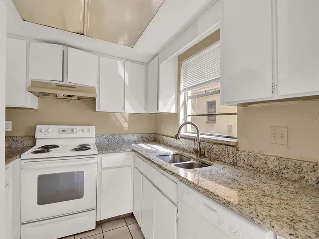 a kitchen with white cabinets sink and white appliances