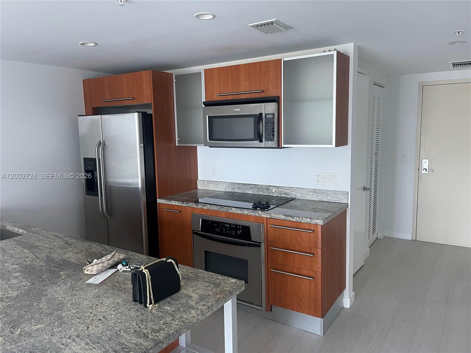 185 Southwest 7th Street, Unit 2705 Miami, FL 33130 - Photo 2 of 5 a kitchen with stainless steel appliances granite countertop a stove a refrigerator and a refrigerator