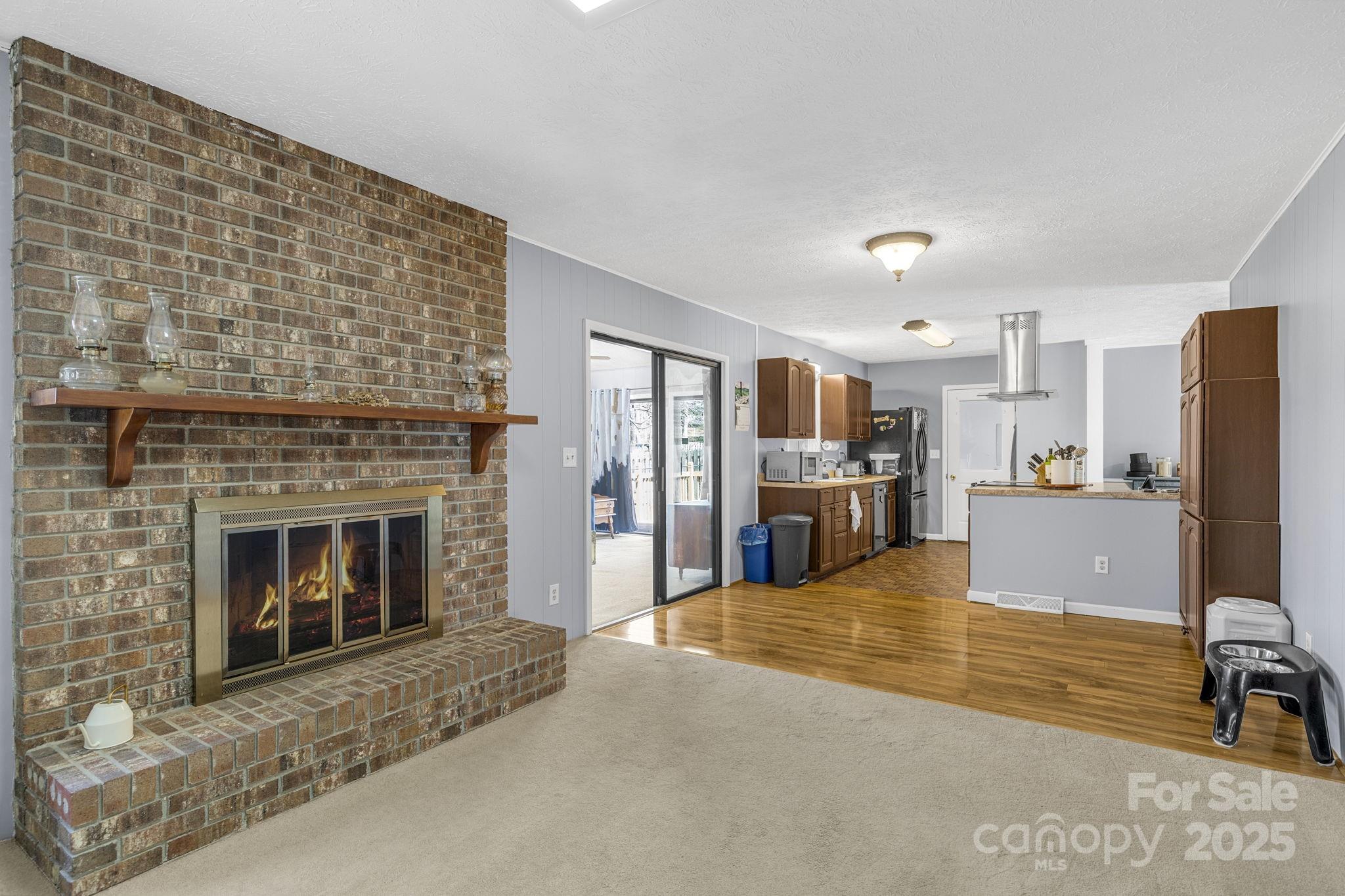 110 Cannon Drive Hendersonville, NC 28792 - Photo 16 of 36 a living room with stainless steel appliances furniture a fireplace and kitchen view