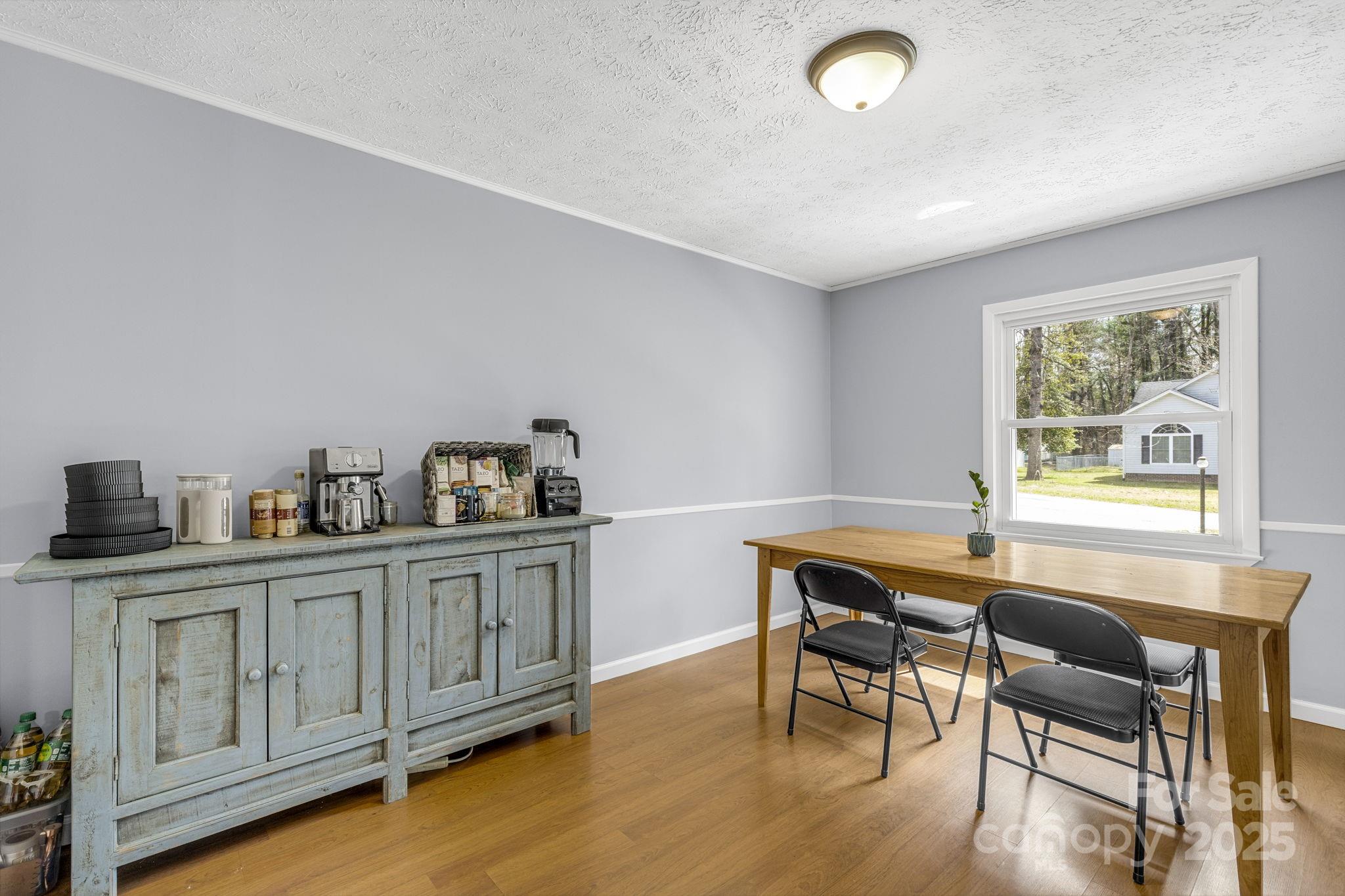 110 Cannon Drive Hendersonville, NC 28792 - Photo 8 of 36 a kitchen with granite countertop a table chairs stove and wooden floor