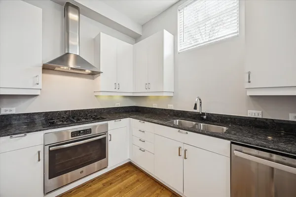 a kitchen with granite countertop white cabinets and a stove