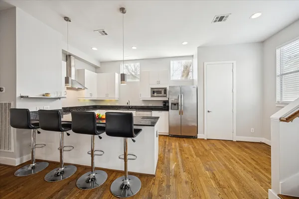 a kitchen with a refrigerator and white cabinets