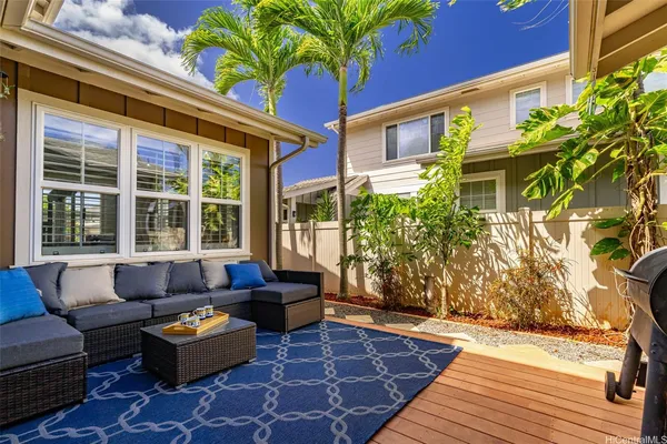 a living room with patio furniture and a potted plant
