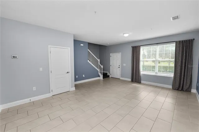 a view of a kitchen with furniture and an empty room