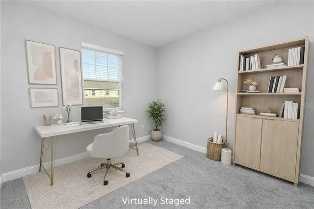 a view of a workspace with furniture and a window