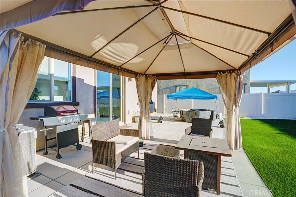 11479 Sheridan Way Beaumont, CA 92223 - Photo 20 of 40 a patio with patio a table and chairs under an umbrella