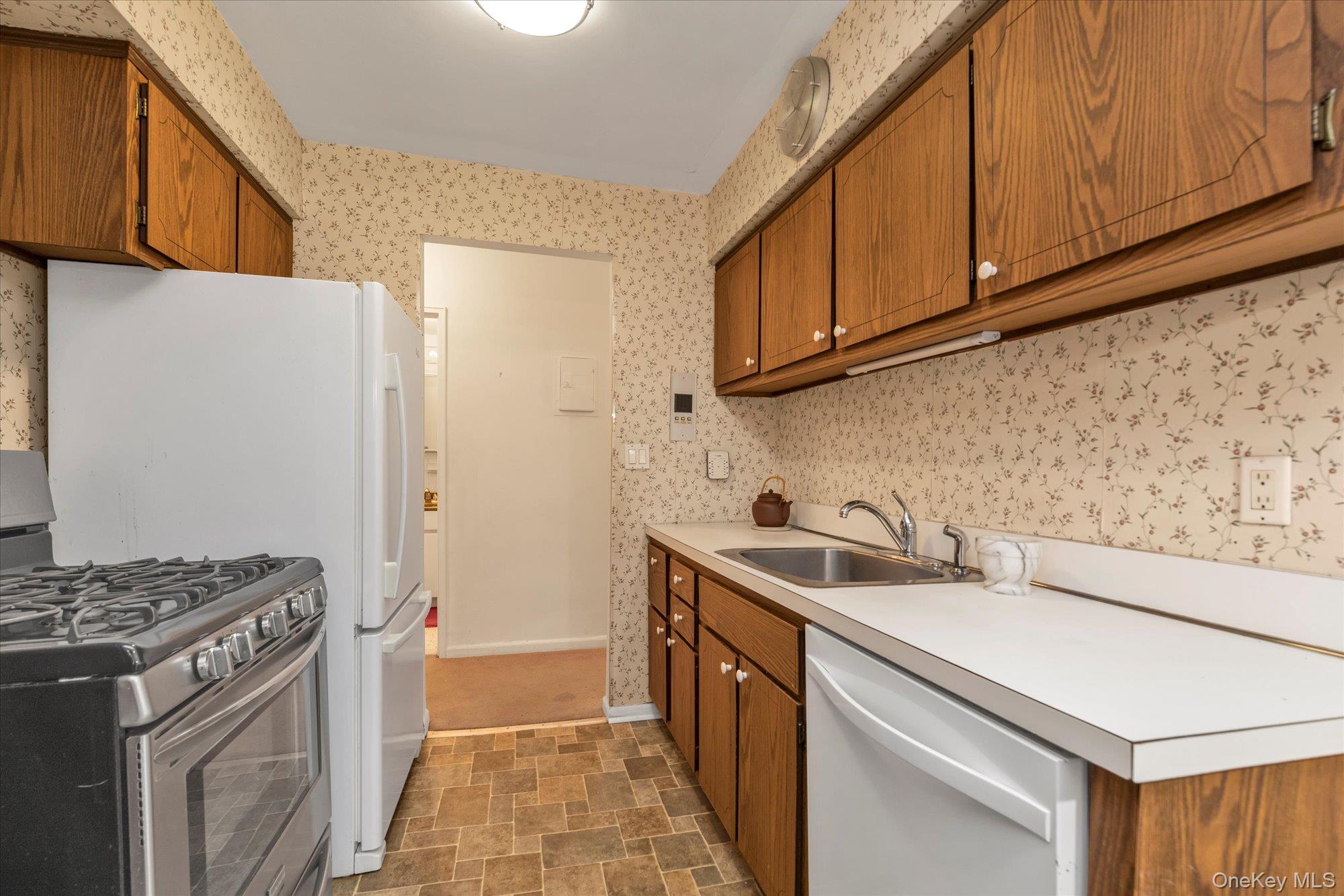 30 Barstow Road, Unit 3A Great Neck, NY 11021 - Photo 7 of 17 a kitchen with stainless steel appliances granite countertop a sink stove and refrigerator
