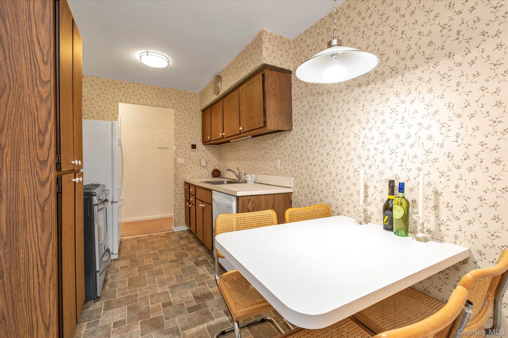30 Barstow Road, Unit 3A Great Neck, NY 11021 - Photo 8 of 17 a kitchen that has a sink and a stove in it