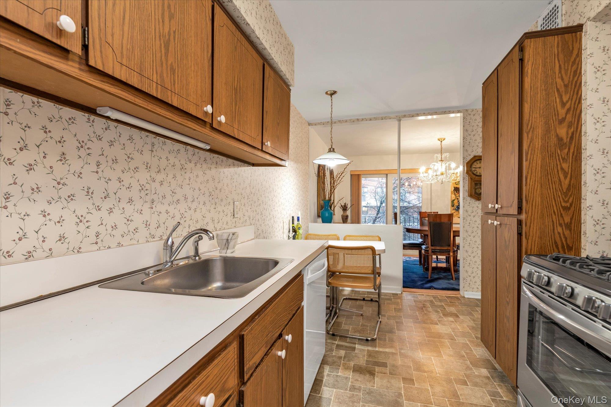 30 Barstow Road, Unit 3A Great Neck, NY 11021 - Photo 9 of 17 a kitchen with sink a refrigerator and cabinets