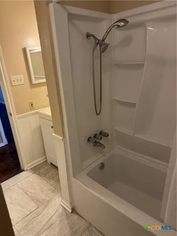 a bathroom with a tub a toilet and a shower