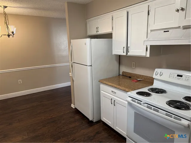 a kitchen with a refrigerator stove and white cabinets