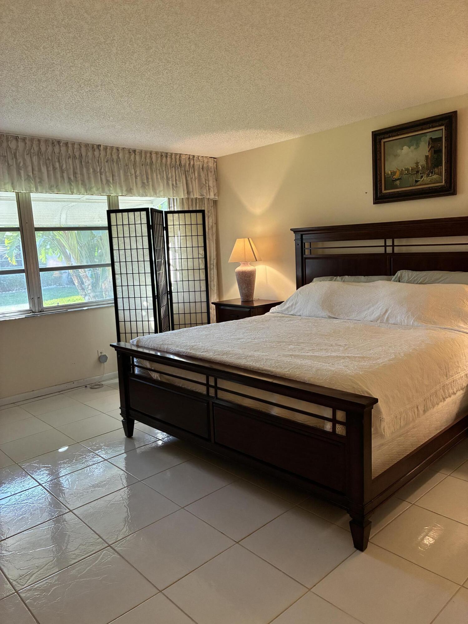 4540 Northwest 3rd Court, Unit C Delray Beach, FL 33445 - Photo 19 of 29 a bedroom with a bed and window