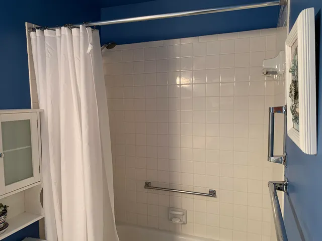 a bathroom with a sink a toilet a mirror and shower