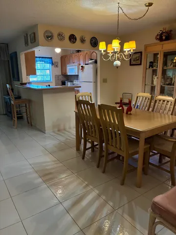 a dining area with a table chairs and a kitchen view