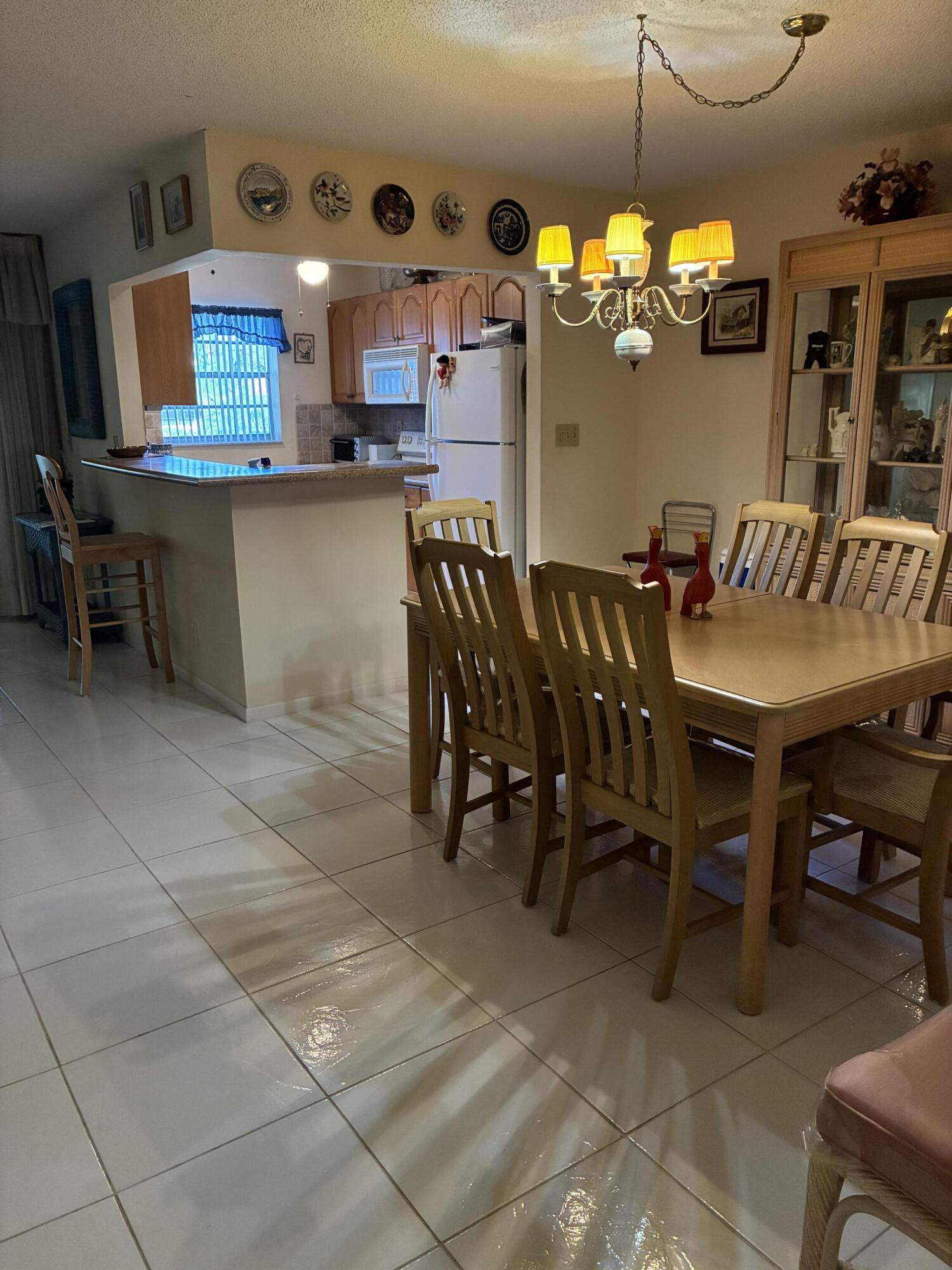 4540 Northwest 3rd Court, Unit C Delray Beach, FL 33445 - Photo 10 of 29 a dining area with a table chairs and a kitchen view