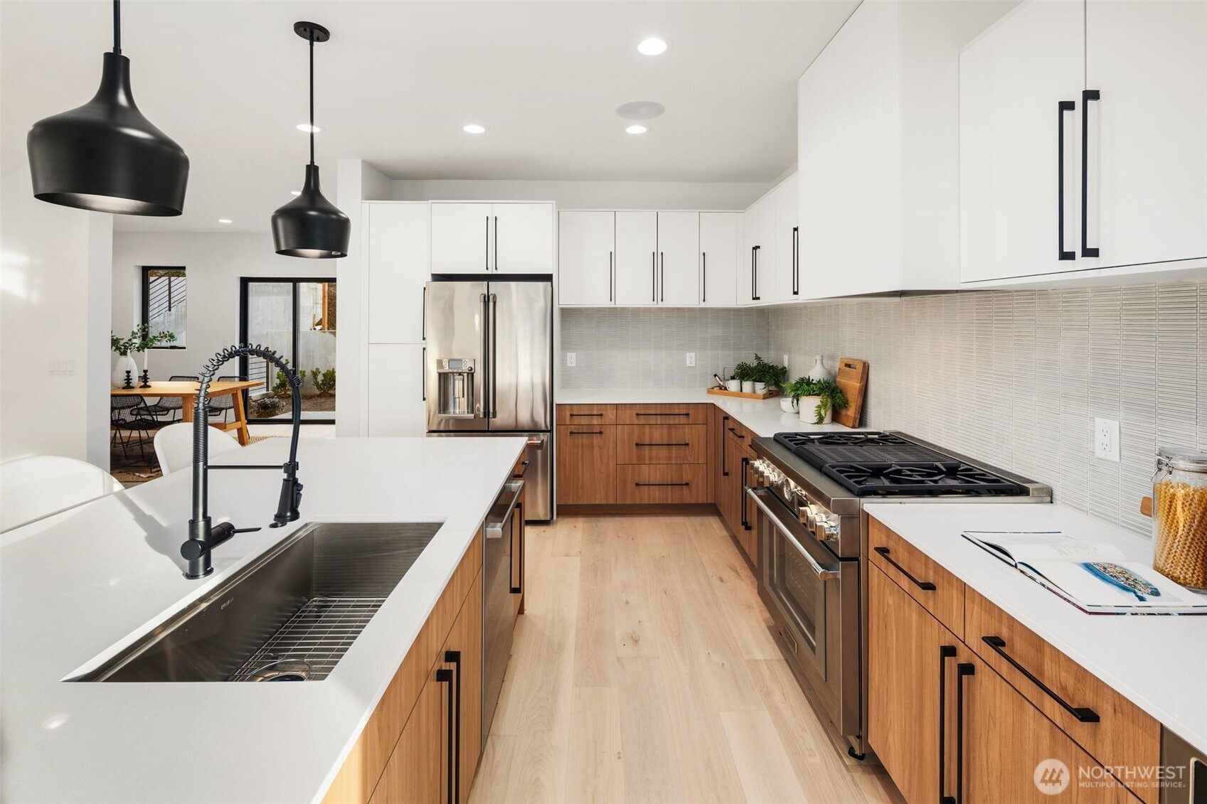 5244 23rd Avenue Southwest Seattle, WA 98106 - Photo 7 of 35 a kitchen with stainless steel appliances granite countertop a sink a stove and a wooden floors