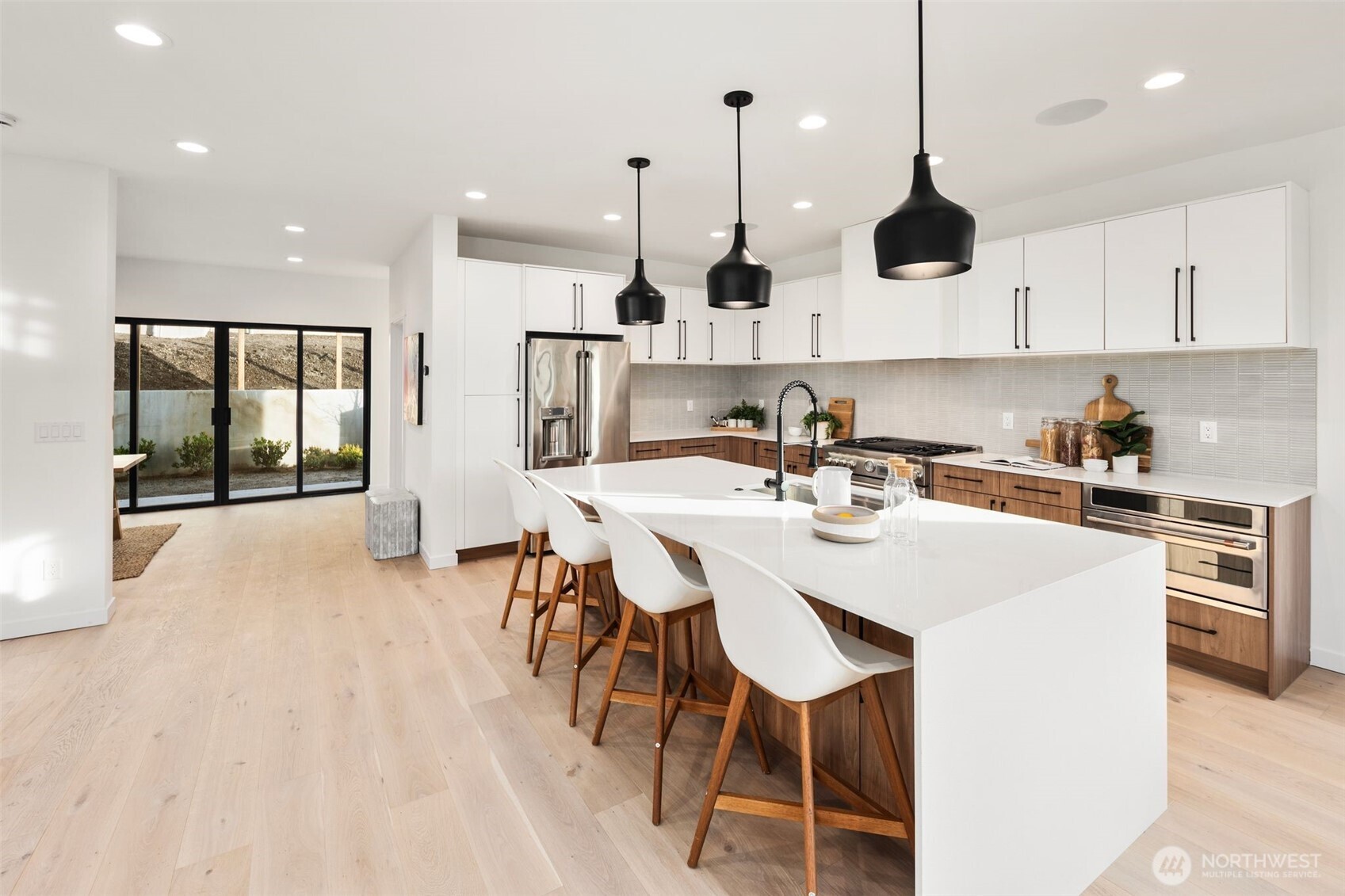 5244 23rd Avenue Southwest Seattle, WA 98106 - Photo 9 of 35 a kitchen with stainless steel appliances kitchen island granite countertop a sink a stove and a refrigerator