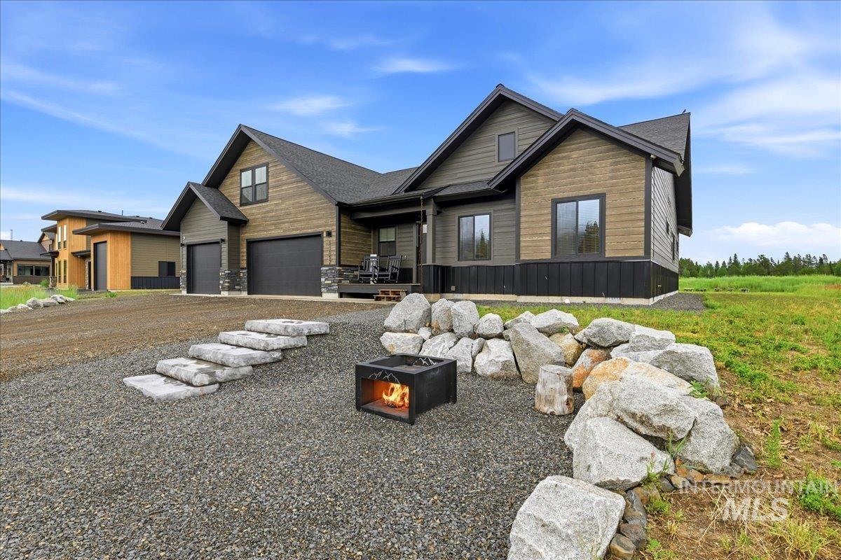 13152 Hawks Bay Road Donnelly, ID 83615 - Photo 3 of 29 Modern exterior featuring wood-look siding, a two-car garage, and a covered porch