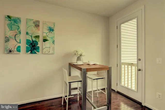 a view of a dining room with wooden floor and a potted plant