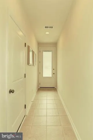 a view of a hallway with wooden floor and a bathroom
