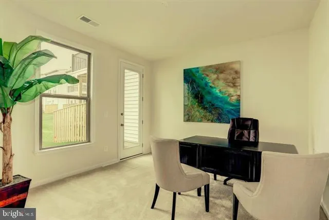 a view of a workspace with furniture and a window